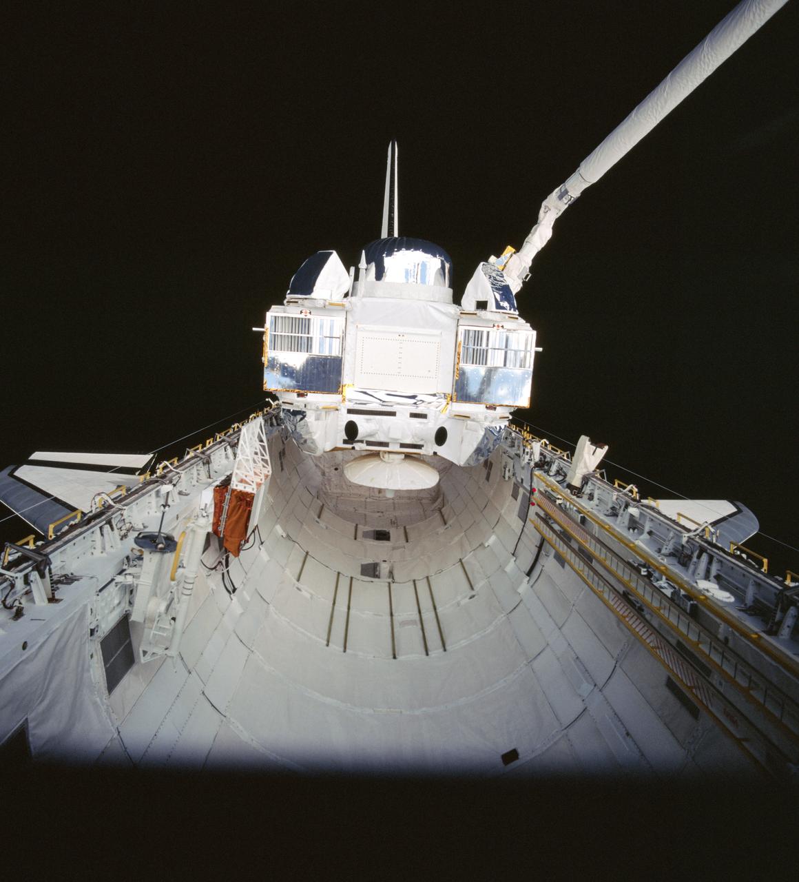 STS037-99-031 (7 April 1991) --- The Gamma Ray Observatory (GRO) is still in the grasp of Atlantis' remote manipulator system (RMS) in this 70mm scene, photographed from inside the crew cabin.  A special extravehicular activity (EVA) was required by astronauts Jerry L. Ross and Jerome (Jay) Apt to manually extend the high-gain antenna on GRO.  The solar array panels are not yet deployed in this scene.  The five-member crew capped off a busy Flight Day 3 by releasing the heavy payload.