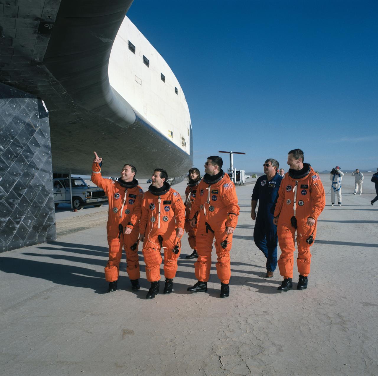 STS037-S-085 (11 April 1991) --- Following their egress from the Space Shuttle Atlantis at Edwards Air Force Base the STS-37 astronauts survey their "home" for the past six days. Pictured, left to right, are astronauts Jerry L. Ross, Jerome J. Apt, Linda M. Godwin, Kenneth D. Cameron, Daniel C. Brandenstein and Steven R. Nagel, mission commander.  Brandenstein, chief of the Astronaut Office at JSC, flew the Shuttle training aircraft and took photographs during Atlantis's landing.  Complete wheel stop occurred at 6:56:26 (PDT), April 11, 1991.