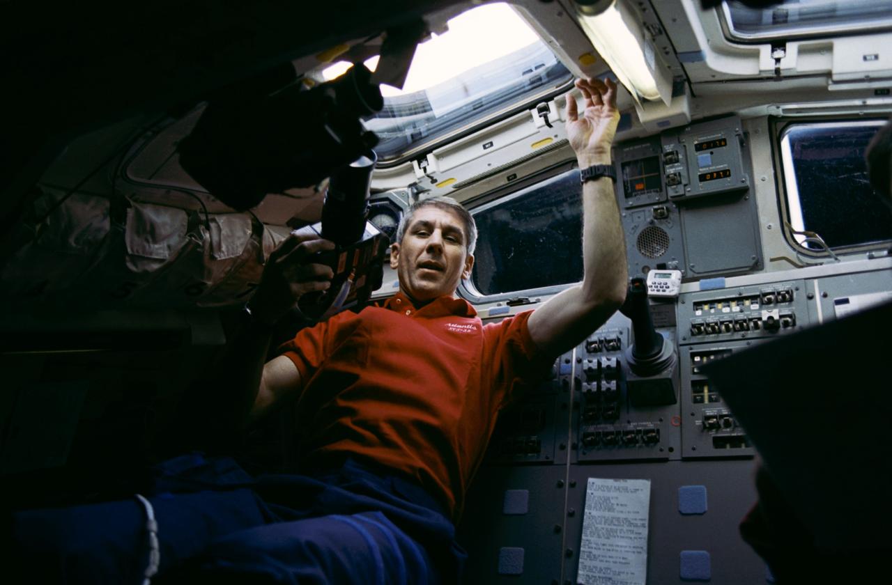 STS038-25-005 (20 Nov 1990) --- STS-38 Mission Specialist (MS) Robert C. Springer, holding HASSELBLAD camera, positions himself under aft flight deck overhead window W7 before recording the Earth's surface below. Behind Springer are Atlantis', Orbiter Vehicle (OV) 104's, on orbit station and aft flight deck viewing windows.