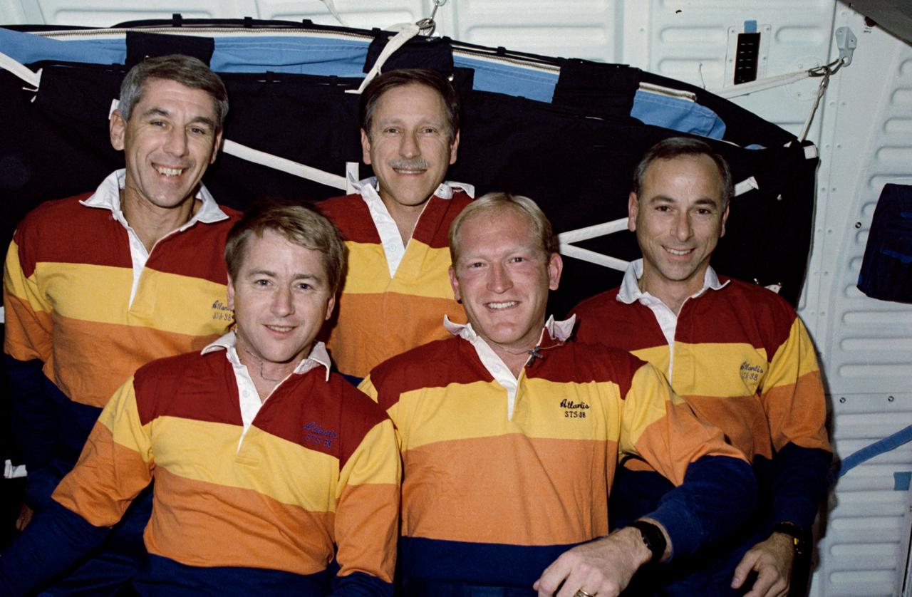 STS038-28-016 (20 Nov 1990) --- STS-38 crewmembers pose on Atlantis', Orbiter Vehicle (OV) 104's, middeck for traditional onboard (in-space) portrait. Wearing red, yellow, and orange crew polo shirts are (right to left) Mission Specialist (MS) Robert C. Springer, Pilot Frank L. Culbertson, Commander Richard O. Covey, MS Charles D. Gemar, and MS Carl J. Meade.