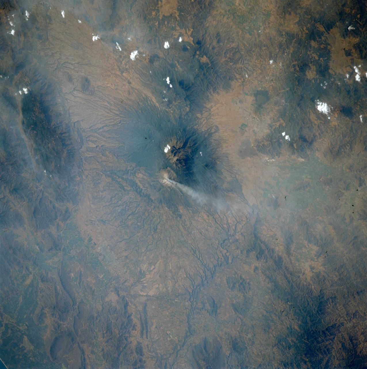 STS039-75-101 (28 April-6 May 1991) --- Spending over eight days in Earth orbit, the STS-39 crew was able to return with photographic coverage of highly variegated geographic scenery, including a number of volcanoes such as Mexico's Colima. Located south of Guadalajara, Colima is Mexico's most active volcano. The current activity started in the first part of March 1991 with avalanches occurring, followed by lava extrusion and ash emission. Colima is captured here in action. The steam plume drifts eastward from the 13,325 ft. summit. Scars from recent landslides can be seen on the southwest flank of the summit.