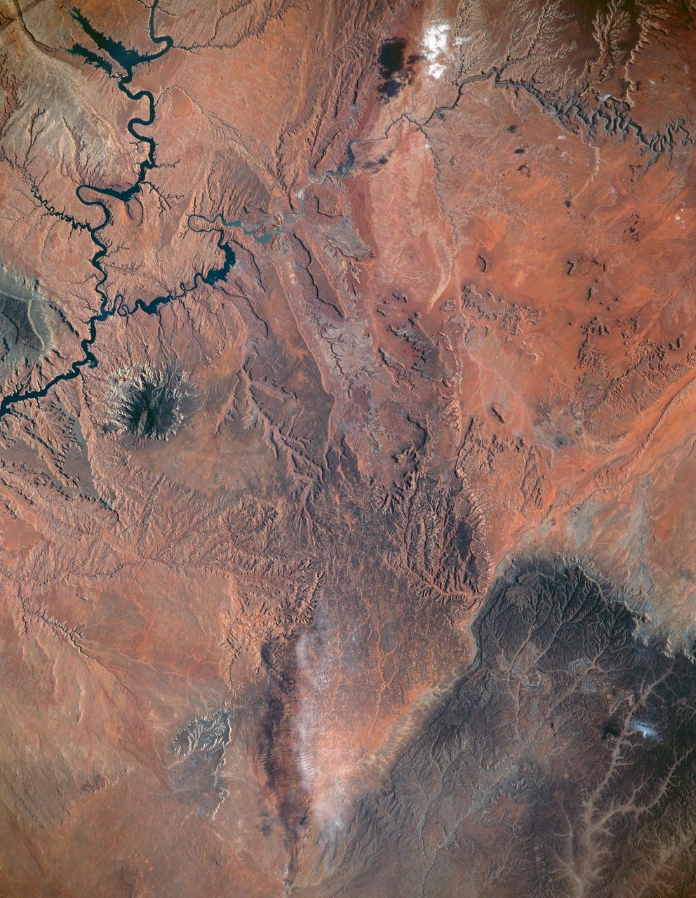 STS040-151-123 (5-14 June 1991) --- This large format view shows parts of northern Arizona and southern Utah.  San Juan River, Lake Powell and Monument Valley are visible.  Water of Lake Powell can be seen filling the valleys of the Colorado and San Juan Rivers at the top of the image.  The darker green areas indicate high, forested country of the lone Navajo Mountain (center left) and Black Mesa (bottom right).  Strip mines can be seen south of the rim of Black Mesa.  Monument Valley lies between the San Juan River and Black Mesa.  Shadows thrown by the individual steep-sided hills make them stand out in the scene.