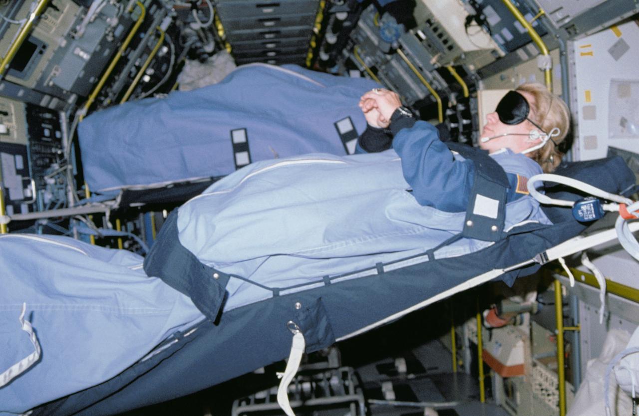 STS040-31-020 (5-14 June 1991) --- During the nine-day mission, some of the crew slept in the SLS-1 module.  Astronaut Rhea Seddon, using various restraints, sleeps horizontally in this scene.  The image was one of 25 visuals used by the STS-40 crew at its Post Flight Press Conference (PFPC) on June 28, 1991.