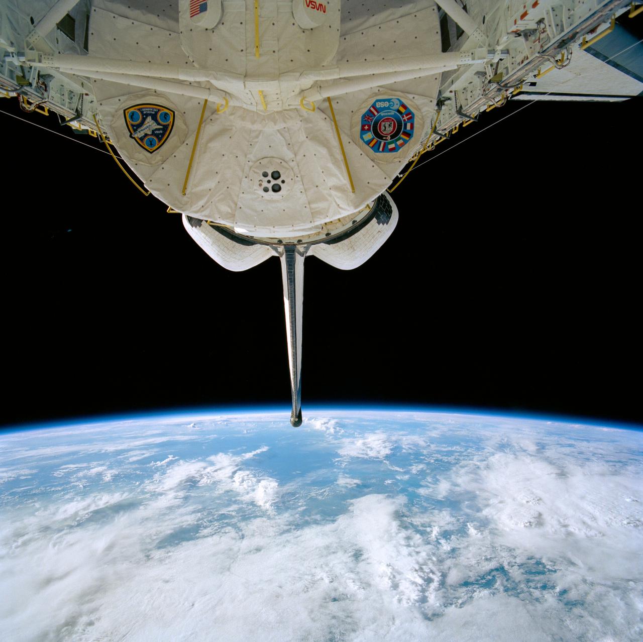 STS040-610-010 (5-14 June 1991) --- The blue and white Earth forms the backdrop for this scene of the Spacelab Life Sciences (SLS-1) module in the cargo bay of the Earth-orbiting Columbia.  The view was photographed through Columbia's aft flight deck windows with a handheld Rolleiflex camera.  Seven crewmembers spent nine days in space aboard Columbia.  Part of the tunnel/airlock system that linked them to the SLS-1 module is seen in center foreground.