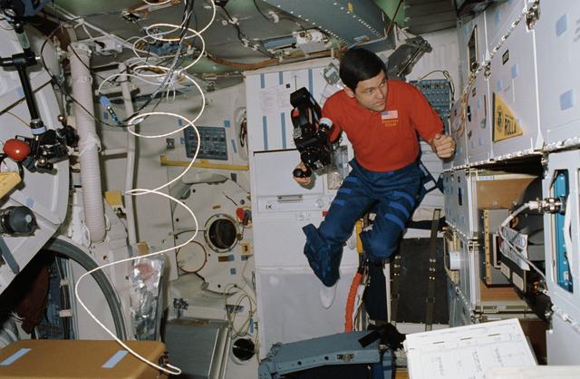 NASA image: STS-41 Pilot Cabana holds 16mm camera on OV-103's middeck