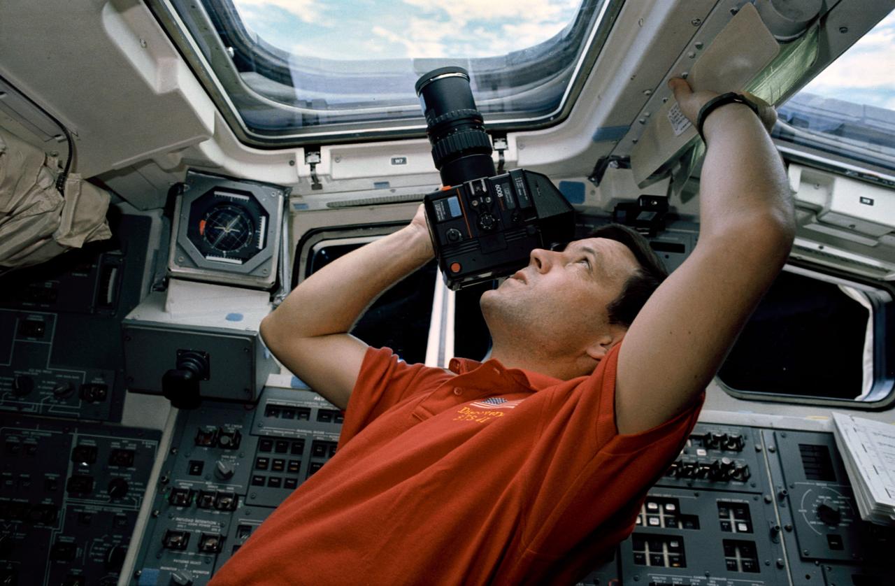 STS041-22-008 (6-10 Oct 1990) ---  Astronaut Robert D. Cabana, STS-41 pilot, uses a handheld camera to  record Earth scenes from the aft flight deck of Discovery.