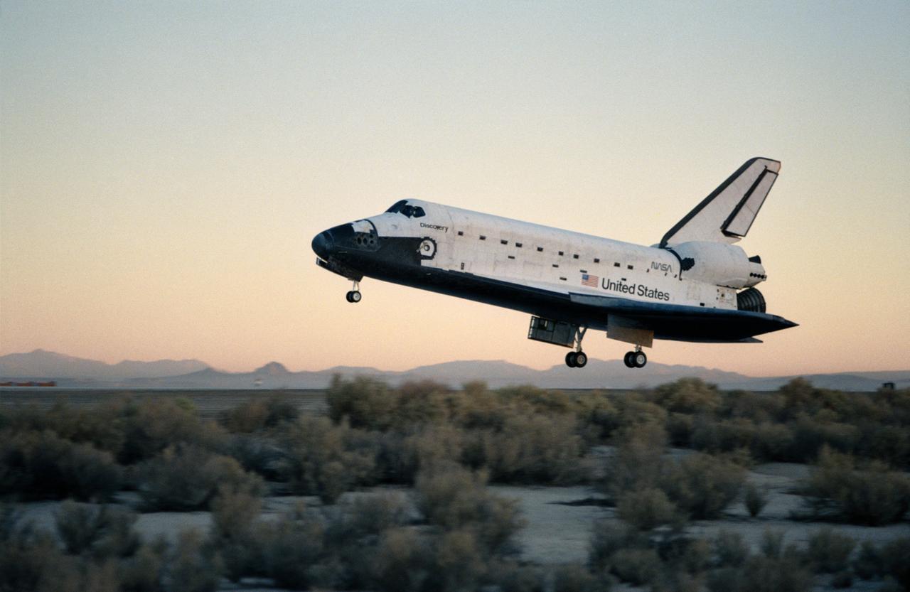 STS-41 Discovery, Orbiter Vehicle (OV) 103, with nose landing gear (NLG) and main landing gear (MLG) deployed, glides over concrete runway 22 at Edwards Air Force Base (EAFB), California, prior to touchdown.