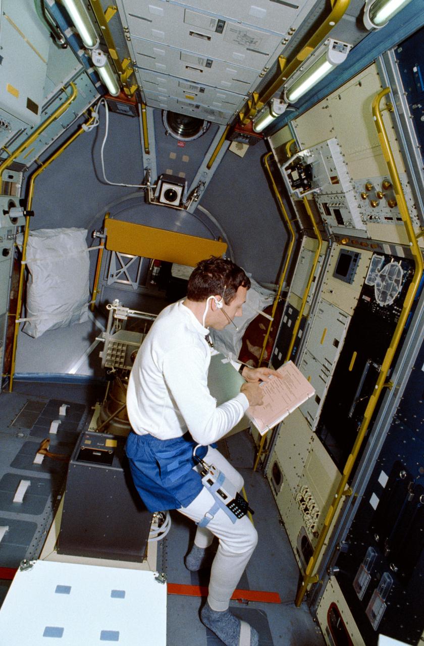 STS042-17-001 (22 Jan 1992)  --- Astronaut David C. Hilmers, mission specialist, looks over a checklist at the Johnson Space Center refrigerator/freezer, in which perishable samples are stowed.  The view gives an overall perspective of the science module -- heavily utilized for eight-days of scientific research supporting the International Microgravity Laboratory (IML-1) -- in Discovery's cargo bay.