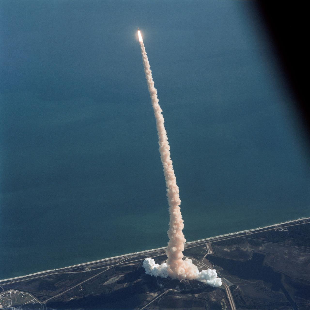 Air-to-air view, taken from the weather-monitoring Shuttle Training Aircraft (STA), shows STS-42 Discovery, Orbiter Vehicle (OV) 103, as it soars above the Atlantic Ocean after liftoff from a Kennedy Space Center (KSC) Launch Complex (LC) Pad at 9:52:33 am (Eastern Standard Time (EST)). The exhaust plume traces OV-103's flight path.
