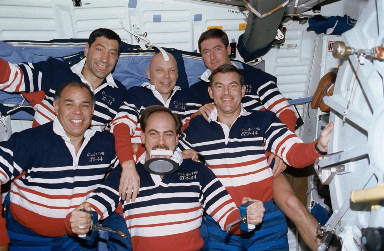 STS044-17-030 (24 Nov-1 Dec 1991) --- The six crewmembers for STS-44 pose for a second crew portrait on Atlantis' flight deck.  This portrait was intended to focus on Payload Specialist Thomas J. Hennen (front center), who earned the nickname, "Trash Man" during the flight.  It was Hennen who "starred" in a brief onboard video production about the disposal of trash and waste.  Others in the picture are (front row) Astronauts Frederick D. Gregory (left), Mission Commander; and James S. Voss, Mission Specialist; and (back row, left to right) Astronauts Mario Runco Jr. and F. Story Musgrave, both Mission Specialists; and Terence T. (Tom) Henricks, Pilot.