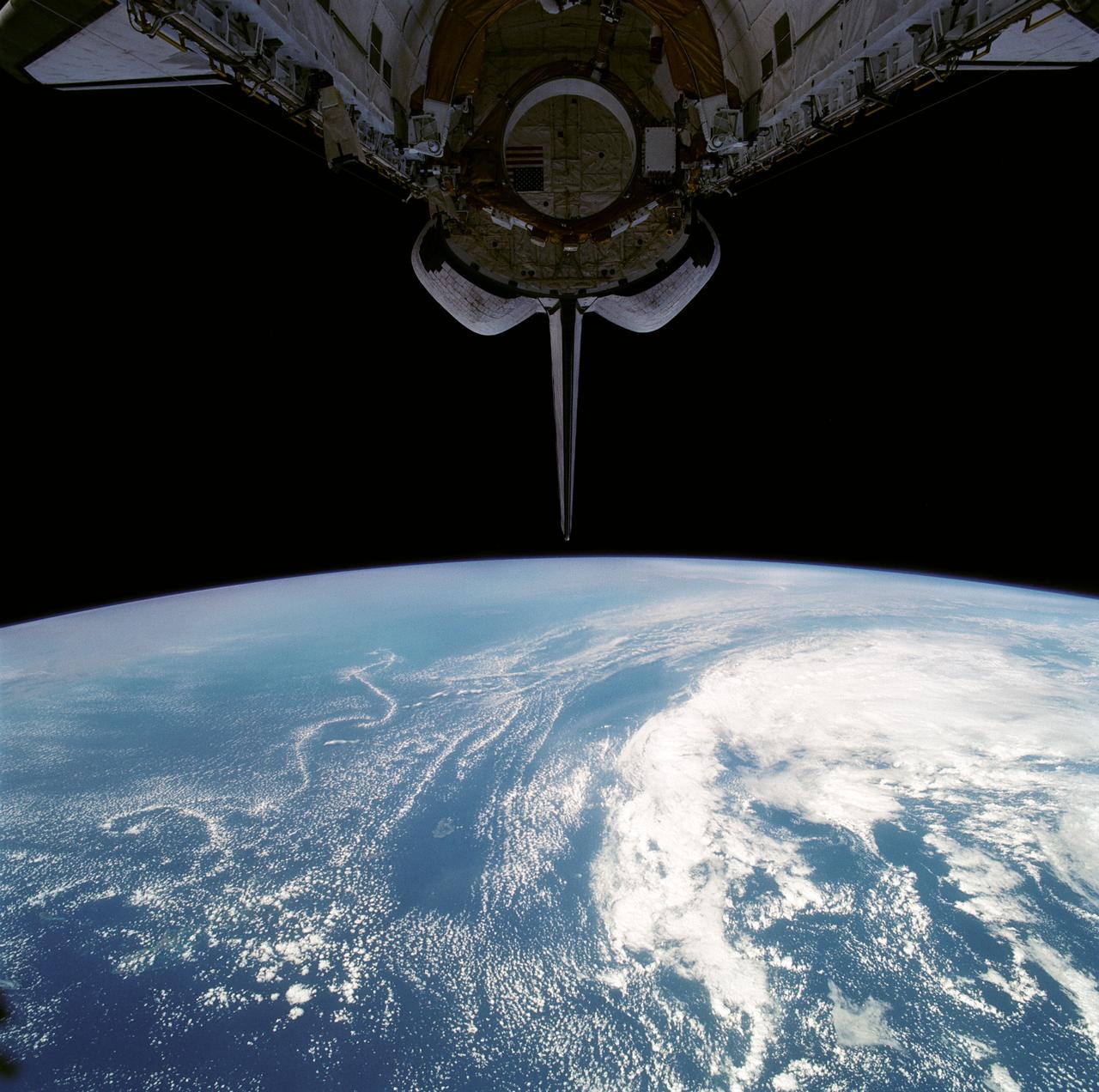 Stable, south flowing air over the western Pacific Ocean (26.0N, 131.0E) is disturbed by islands south of Korea, resulting in sinuous clouds known as von Karman vortices. The smoke plume from Japan's Mount Unzen Volcano on Kyushu, is visible just west of the large cloud mass and extending southward. A very large, purple tinged dust pall, originating in Mongolia, can be seen on the Earth's Limb, covering eastern China and extending into the East China Sea.