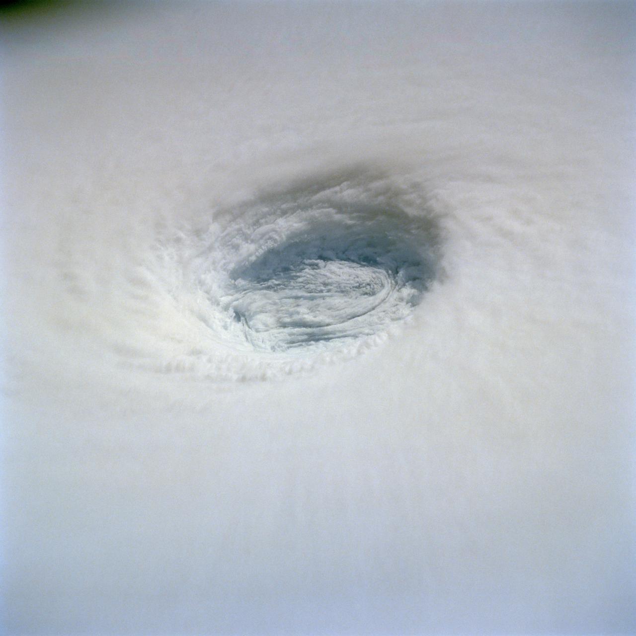 This detailed view of the eye of Supertyphoon Yuri (19.0N, 140.0E) shows the bowl shaped structure of the eye wall. The eye cylinder descends almost to the ocean surface, some 45,000 to 50,000 ft. In this case, the eye is filled with clouds but in most cases, the cylinder is at least partially clear so that the sea surface is visible. The storm at this time was at it's most intense with maximum sustained winds of 165 mph and gusting to 200 mph.