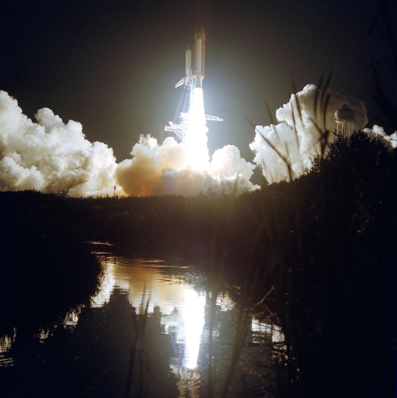 STS044-S-095 (24 Nov 1991) --- A wide shot of Atlantis' liftoff for STS-44 was recorded by a remote camera.  At 6:44 EST, Nov. 24, 1991, the spacecraft headed toward Earth orbit with a crew of six aboard.  The event is reflected in the KSC marsh waters.  Darkness accentuates the diamond shock effect from the three main engines.