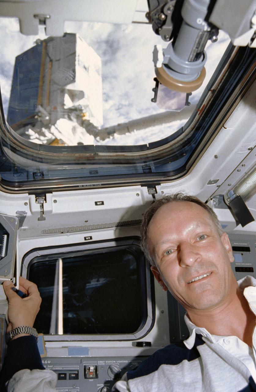 STS046-01-019 (1 Aug 1992) --- Claude Nicollier, representing the European Space Agency (ESA) onboard the Space Shuttle Atlantis for the mission, is seen on the flight deck during pre-deployment operations with the ESA's EURECA satellite.  EURECA can be seen on the end of the Remote Manipulator System (RMS).  Nicollier was joined by five NASA astronauts and an Italian payload specialist for eight days aboard the Atlantis.