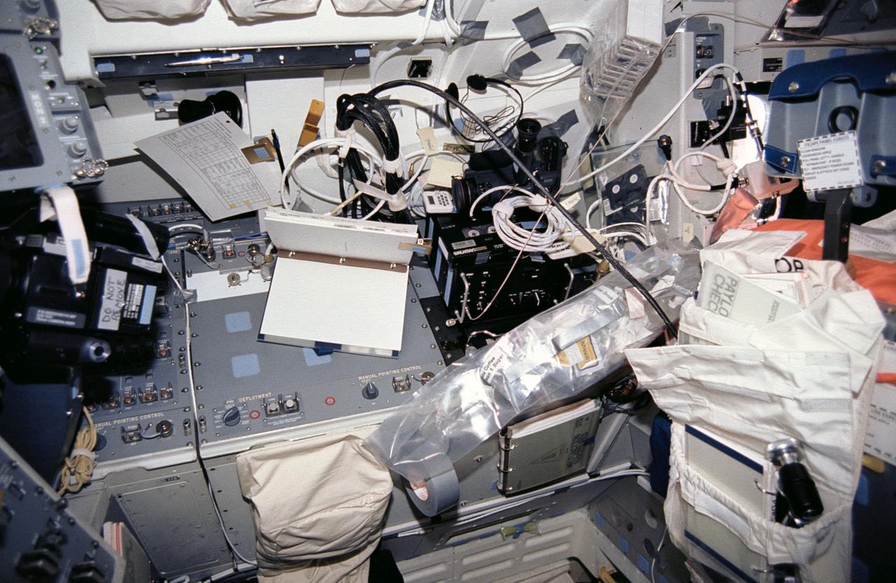 STS046-01-024 (31 July-8 Aug 1992) --- This area on the Space Shuttle Atlantis' flight deck forward port side was referred to as "Marsha's (Ivins) work station" by fellow crew members who good-naturedly kidded the mission specialist and who usually added various descriptive modifiers such as "messy" or "cluttered".  Food, cameras, camera gear, cassettes, cable, flight text material and other paraphernalia can be seen in the area, just behind the commander's station.