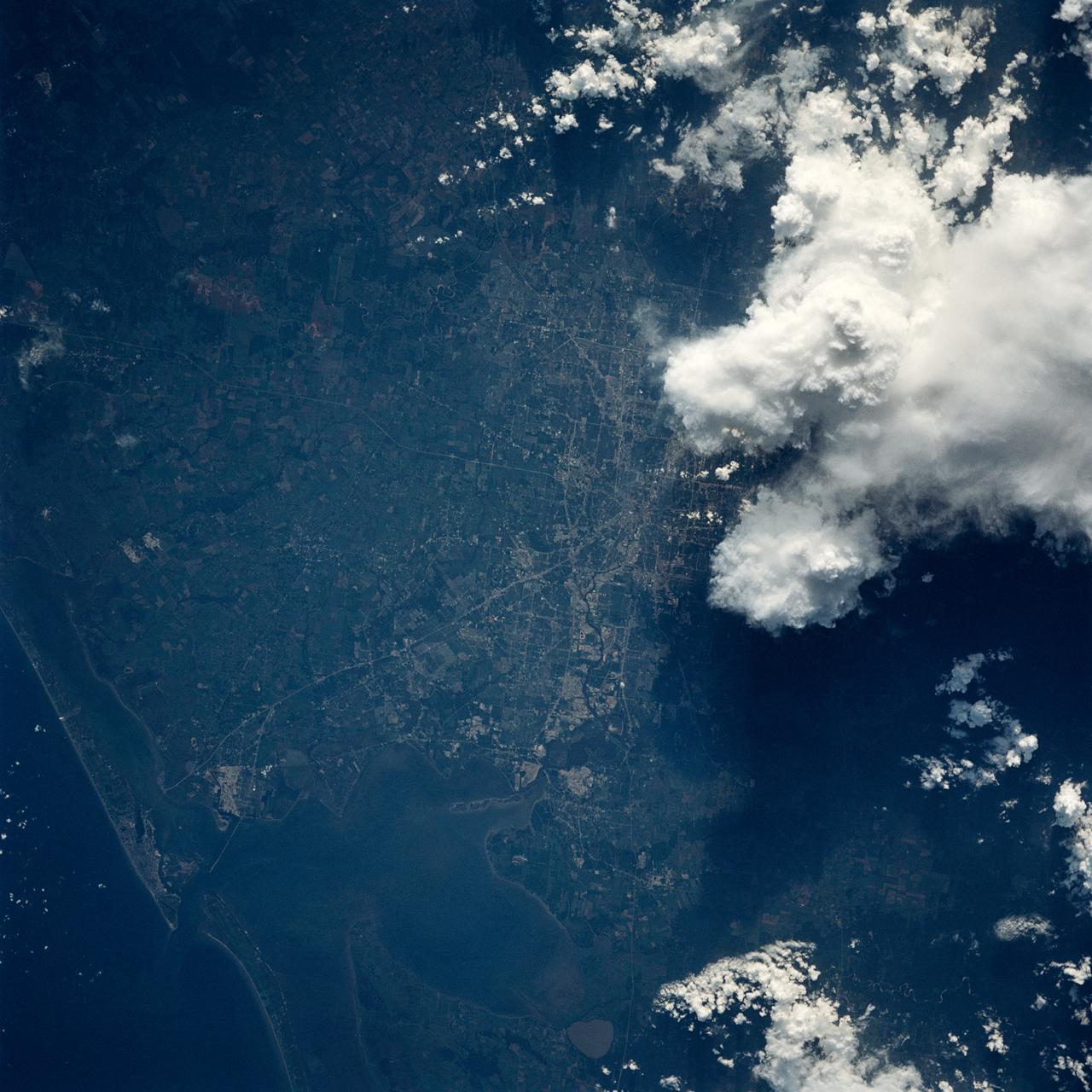 In this view of Houston/Galveston, Texas, USA (29.5N, 95.5W), heavy spring rains emphasize the several bodies of water in the area. Even though partially cloud covered, the progressive nature of the Houston highway and freeway system can easily be observed in this highly detailed view. To the south, the NASA, Clear Lake area just off of Galveston Bay can easily be seen. In the center, is the downtown business district.