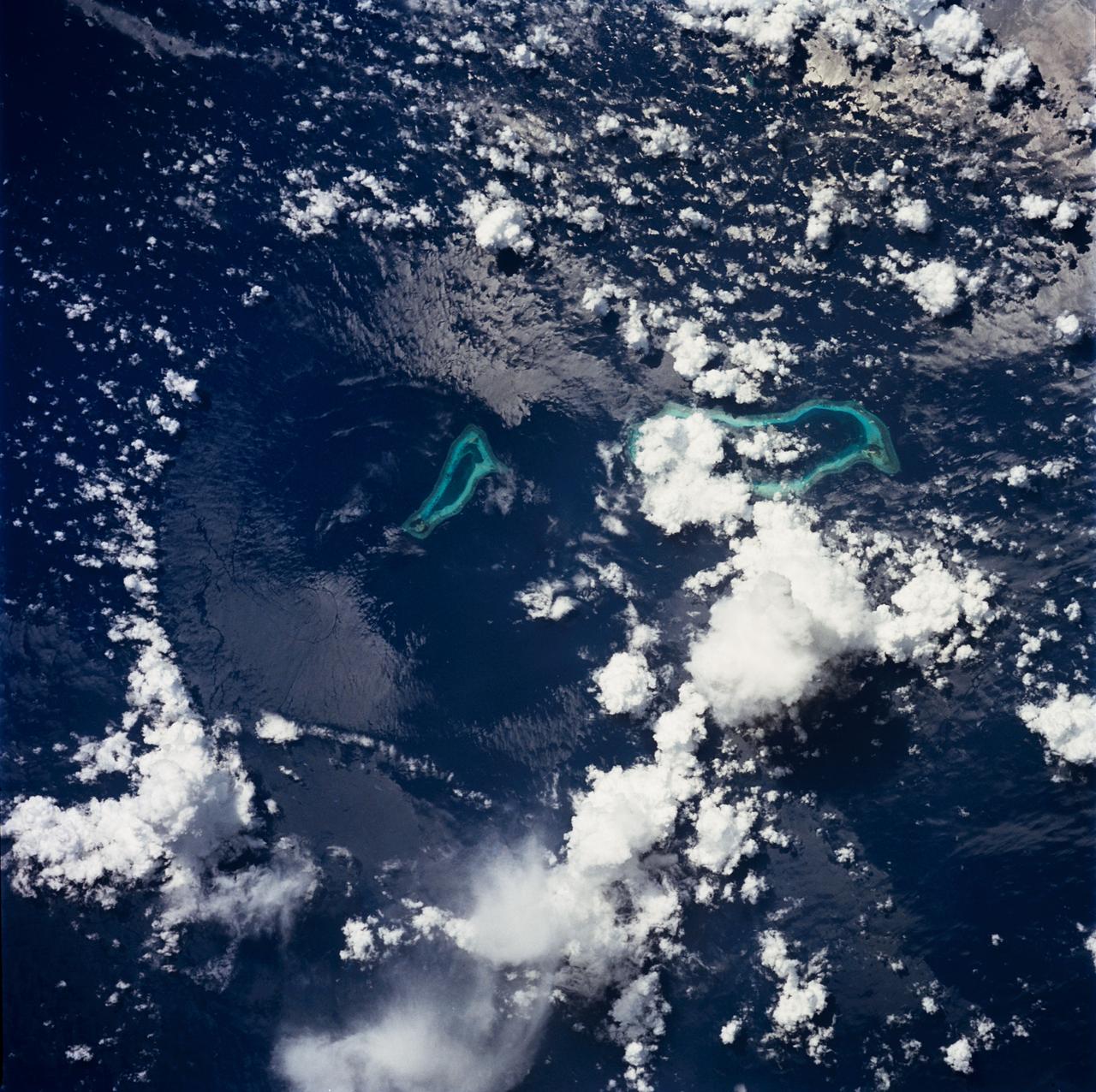 STS049-71-042 (8 May 1992) --- This photograph, taken from the Earth-orbiting Space Shuttle Endeavour, shows a collapsed thunderstorm in the southwestern Pacific Ocean. The clouds were pushed from this circular area of the ocean's surface by relatively cool air that spread downward and outward from a dying thunderstorm. Around the edges of the downdrafted air, new, though smaller, storms are developing. The photo was taken on May 8, 1992, between Borneo and the Philippine island of Mindoro. Two coral atolls can be seen near the center of the photograph. The crew members used a handheld Hasselblad camera, 250-mm lens, color film to expose the image.