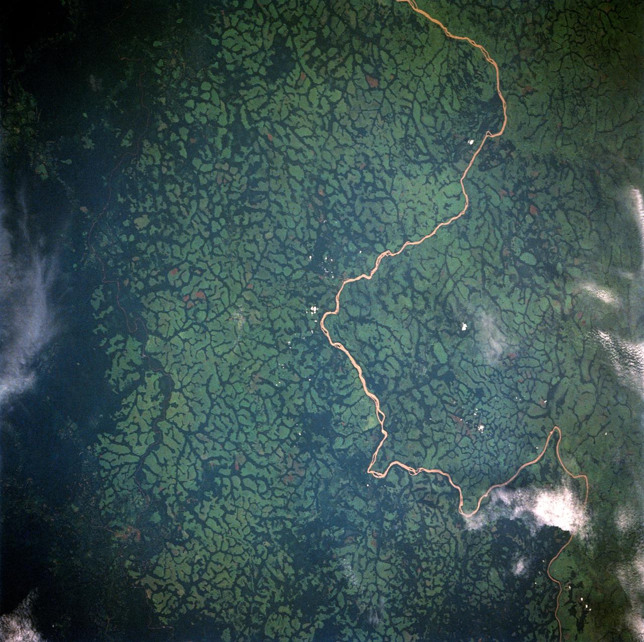 STS049-91-079 (7 - 16 May 1992) --- This 70mm frame, photographed from the Earth-orbiting Space Shuttle Endeavour, features a dendritic drainage pattern in Zaire.  Cleared pasture land shows light green in this color photograph, in contrast to the dark, closed-canopy forest of Zaire.  Remnant woodland along minor streams indicates the intricate drainage network of this hilly region.  Scattered vegetation-free spots show the deep red, tropical soil of the region.  The sediment-laden stream is the Vele River just west of the village of Niangara.  A crew member used a 70mm handheld Hasselblad camera with a 250mm lens to record the image.