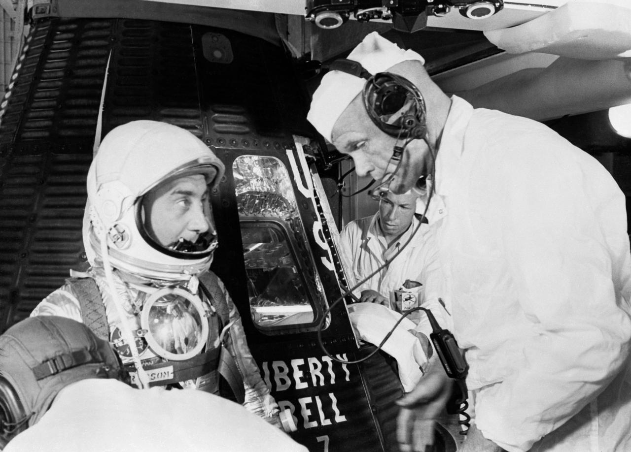 S61-02882 (1961) --- Astronaut Virgil I. (Gus) Grissom, suited up and ready to climb into Liberty Bell 7 spacecraft, talks with backup pilot John H. Glenn prior to insertion. The Mercury-Redstone 4 (MR-4) mission was scrubbed a few hours later due to unfavorable weather over the launch pad. Photo credit: NASA