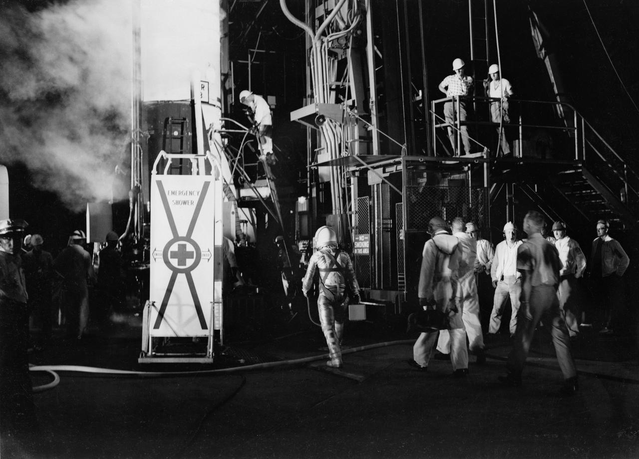 S61-02889 (1961) --- Astronaut Virgil I. (Gus) Grissom approaches his Mercury-Redstone 4 (MR-4) launch vehicle to begin his mission. To the left of the view is an emergency shower stall, to the right is the elevator which will take Grissom to the capsule. Photo credit: NASA