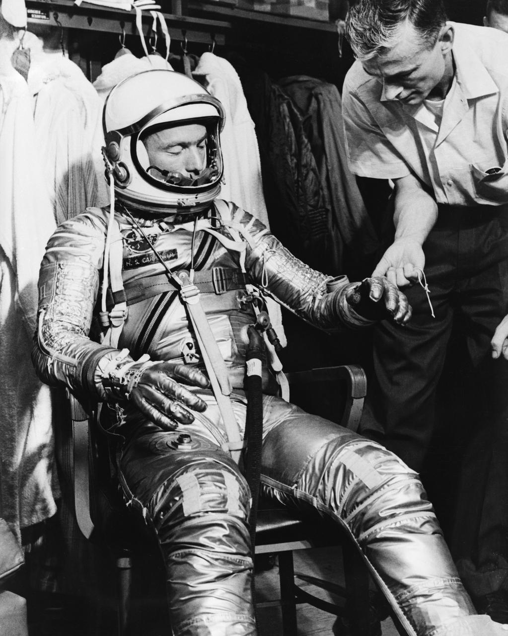 S61-03522 (1961) --- Mercury astronaut M. Scott Carpenter, prime pilot for the Mercury-Atlas 7 (MA-7) spaceflight, and Crew Equipment Specialist Joe Schmitt are pictured during a suiting exercise. Schmidt is seen checking the gloves on Carpenter's pressure suit. Photo credit: NASA