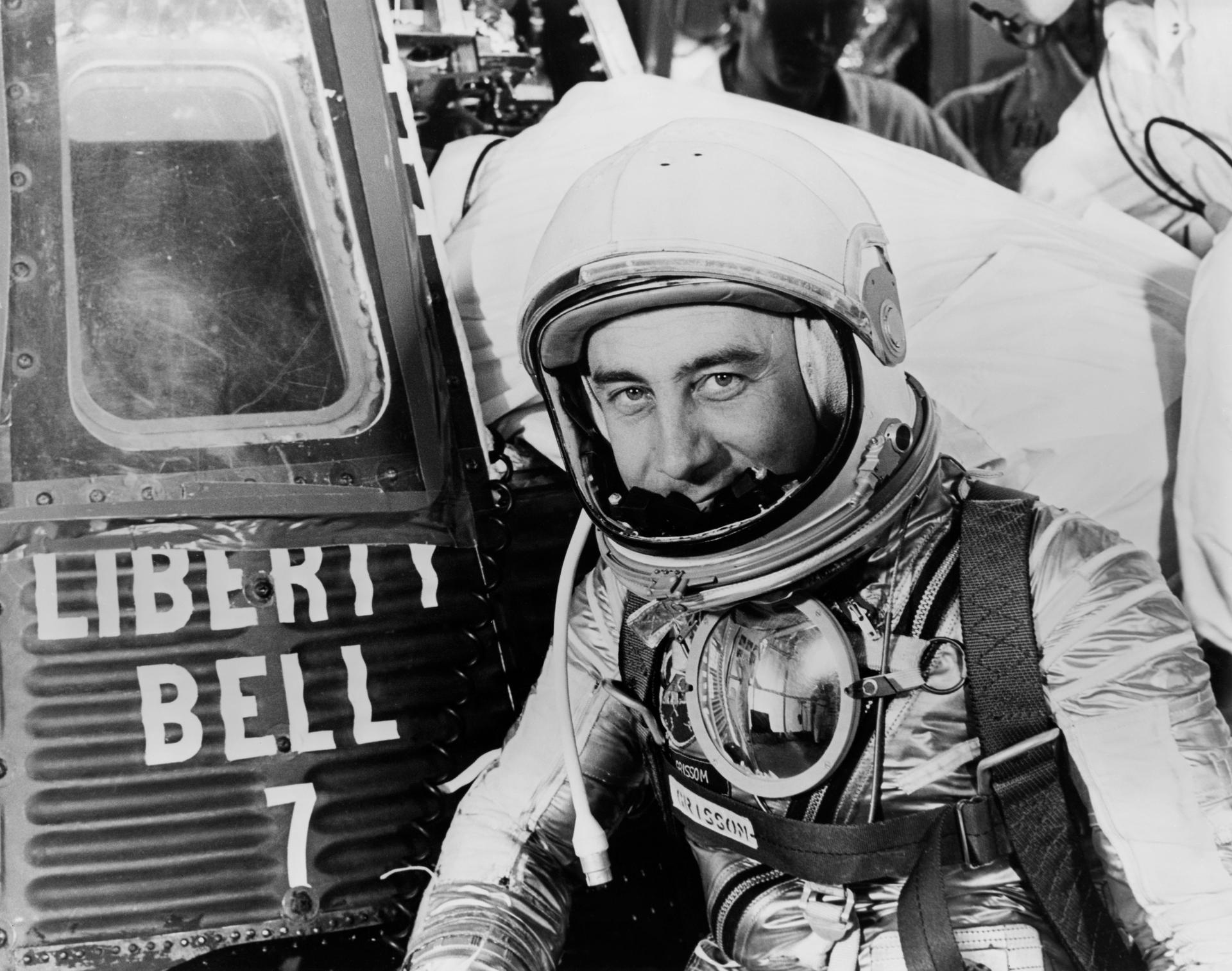 S61-03698 (1961) --- Astronaut Virgil I. (Gus) Grissom, suited up and ready to climb into Liberty Bell 7 spacecraft, sits in front of his capsule for a picture. Behind him technicians work inside the capsule. The Mercury-Redstone 4 (MR-4) mission was scrubbed a few hours later due to unfavorable weather over the launch pad.