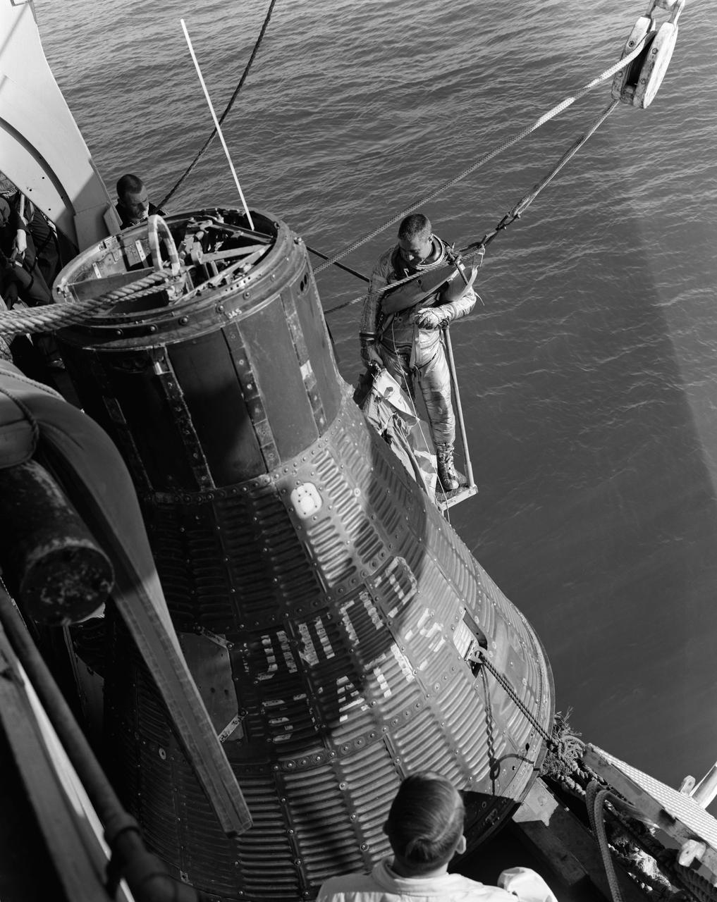 S61-03885 (26 April 1961) --- Astronaut Virgil I. (Gus) Grissom, wearing the new Mercury spacesuit, stands outside of a mock-up of the Mercury capsule on the deck of a ship taking him to emergency water egress training activities. Photo credit: NASA