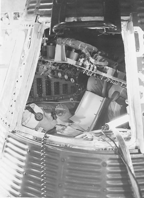 S61-03744 (July 1961) --- Astronaut John H. Glenn Jr., backup astronaut for MR-4, inspects the interior of a Mercury spacecraft on Pad 5. He is reviewing material on the checklist he is holding against the consoles in front of him. Photo credit: NASA