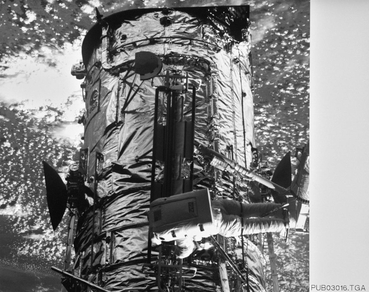 S61-E-011 (5 Dec 1993) --- This view of astronaut Kathryn C. Thornton working on the Hubble Space Telescope (HST) was photographed with an Electronic Still Camera (ESC), and down linked to ground controllers soon afterward.  Thornton, anchored to the end of the Remote Manipulator System (RMS) arm, is installing the +V2 Solar Array Panel as a replacement for the original one removed earlier.  Electronic still photography is a relatively new technology which provides the means for a handheld camera to electronically capture and digitize an image with resolution approaching film quality.  The electronic still camera has flown as an experiment on several other shuttle missions.