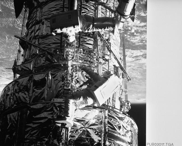 NASA image: Astronauts Thornton & Akers on HST photographed by Electronic Still Camera