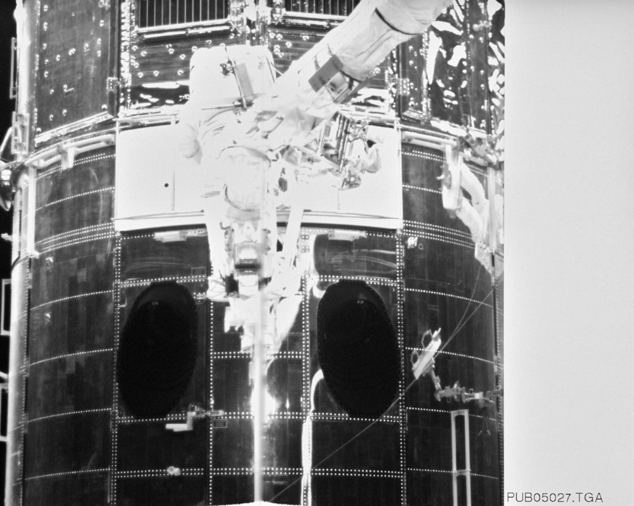 S61-E-018 (6 Dec 1993) --- Astronaut Jeffrey A. Hoffman, anchored to a foot restraint on the end of the Remote Manipulator System (RMS) arm, inserts the new Wide Field/Planetary Camera (WFPC-II) into its place on the Hubble Space Telescope (HST). Astronaut F. Story Musgrave, who shared the duties of replacing the camera, is partially visible at right edge of frame. Electronic still photography is a relatively new technology which provides the means for a handheld camera to electronically capture and digitize an image with resolution approaching film quality. The electronic still camera has flown as an experiment on several other shuttle missions.