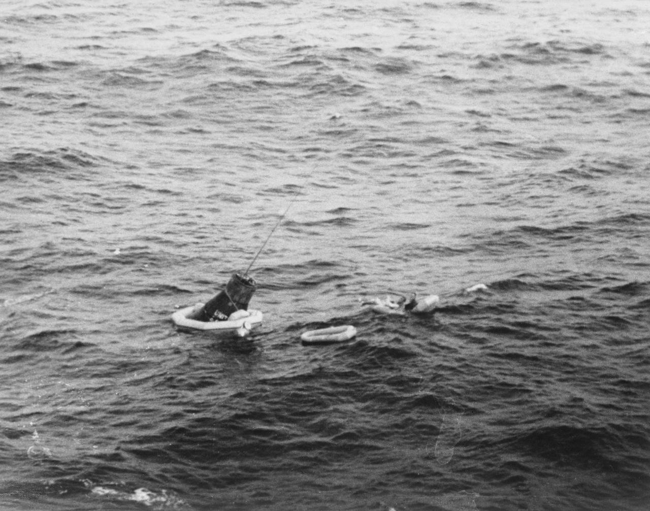 S62-04065 (24 May 1962) --- Astronaut M. Scott Carpenter, prime pilot for the Mercury-Atlas 7 (MA-7) mission, is seen being recovered from the Atlantic Ocean after MA-7 flight. A diver helps Carpenter into a life raft while the capsule floats nearby. Photo credit: NASA