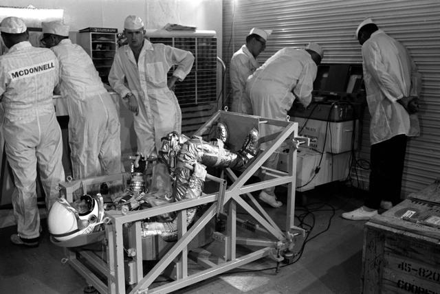 Astronaut L. Gordon Cooper on weight and balance scale 