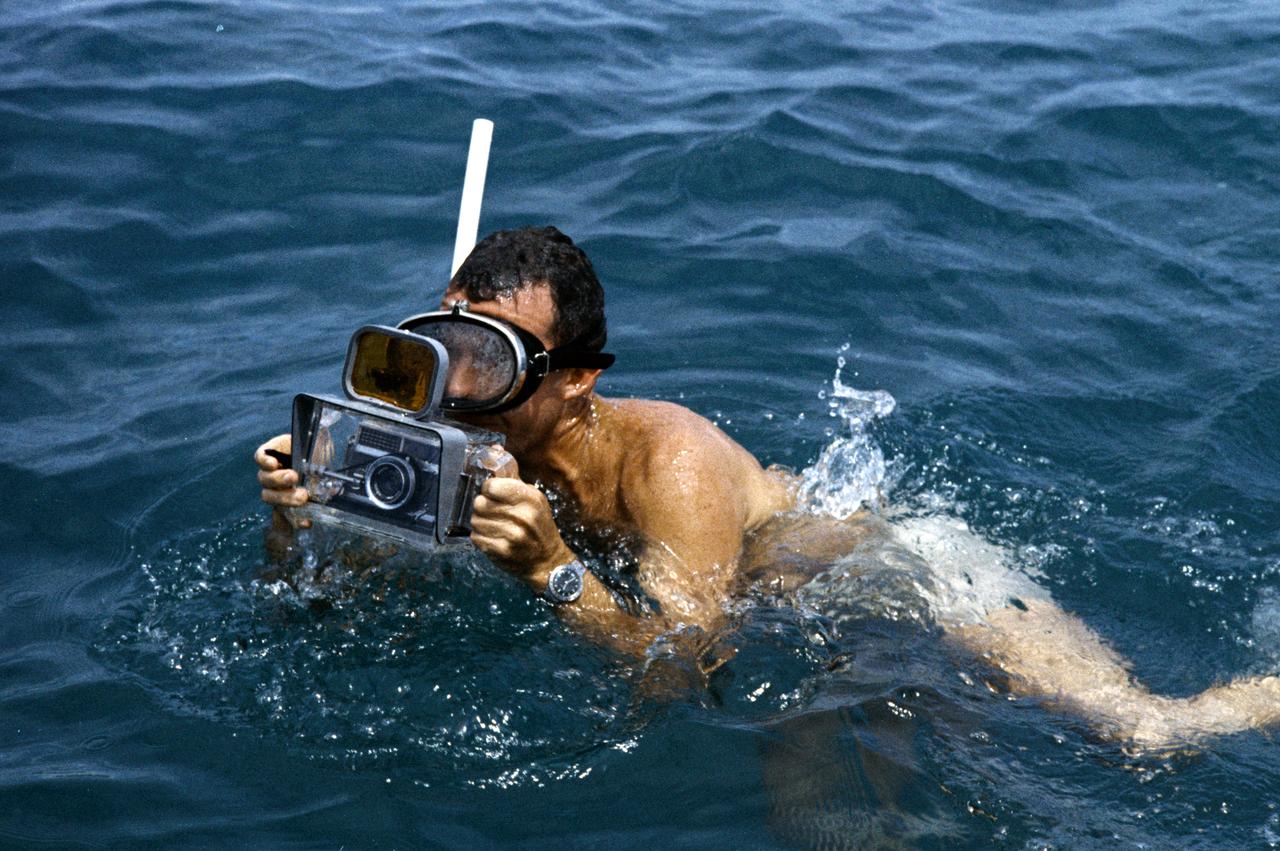 S62-05161 (1962) --- Astronaut L. Gordon Cooper Jr. participates in Mercury water egress training. He is wearing a snorkel and holding a camera for underwater photography. Photo credit: NASA