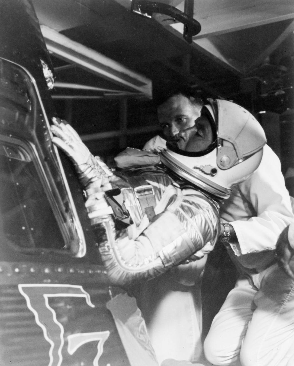 S62-06002 (3 Oct. 1962) --- Astronaut Walter M. Schirra Jr., pilot of the Mercury-Atlas 8 (MA-8) Earth-orbital spaceflight, is assisted by backup pilot L. Gordon Cooper into his Sigma 7 spacecraft for the begining of the MA-8 mission. Photo credit: NASA