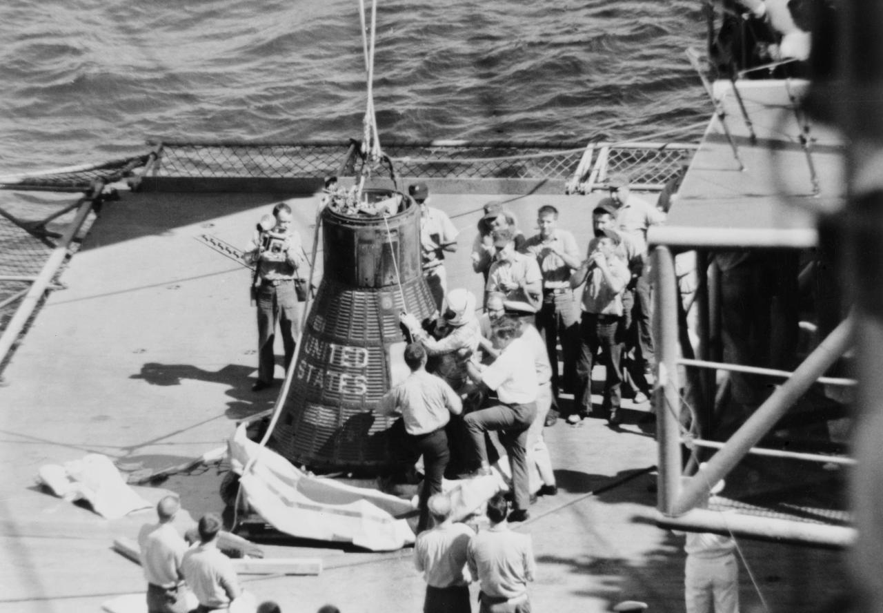 S62-06144 (3 Oct. 1962) --- Wide angle view of Mercury-Atlas 8 (MA-8) astronaut Walter Schirra Jr. being removed from his Sigma 7 capsule by Navy personnel. Photo credit: NASA