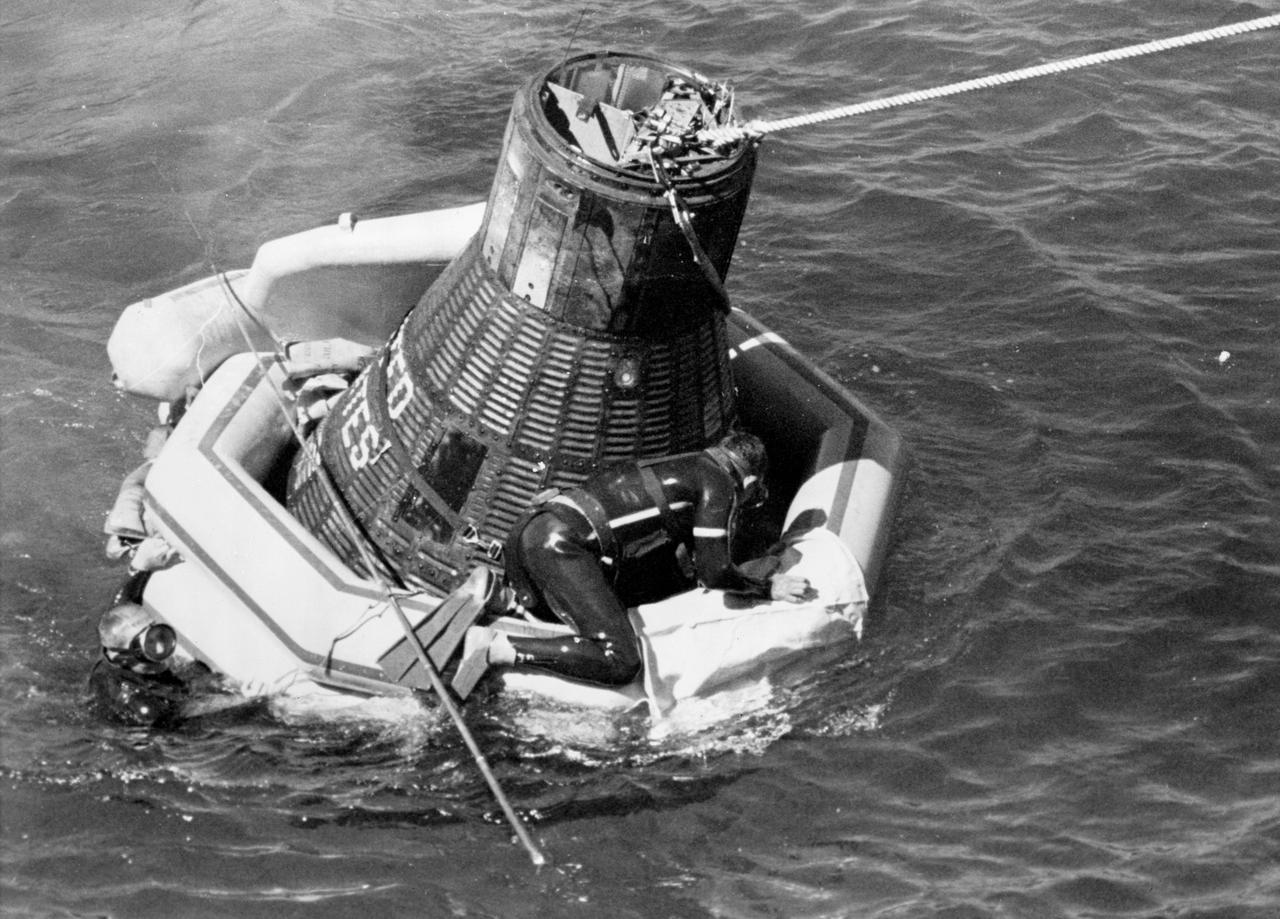 S62-061060 (3 Oct. 1962) --- Navy frogman astride Mercury-Atlas 8 caspule, the Sigma 7, floatation collar to secure tow line for recovery by USS Kearsarge. Photo credit: NASA