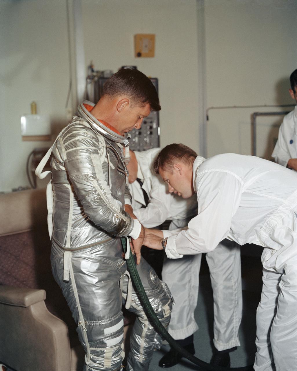 S62-08895 (1962) --- Astronaut Walter M. Schirra Jr., pilot of the Mercury-Atlas 8 (MA-8) Earth-orbital spaceflight, goes through a suiting-up exercise in Hangar "S" at Cape Canaveral several weeks prior to his scheduled Oct. 3, 1962 flight. Photo credit: NASA