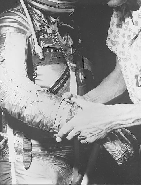 S62-00249 (1962) --- View of astronaut John H. Glenn Jr. being fitted with gloves for his spacesuit during preflight training activities at Cape Canaveral, Florida. Glenn is assisted by suit technician Joe Schmitt. Photo credit: NASA