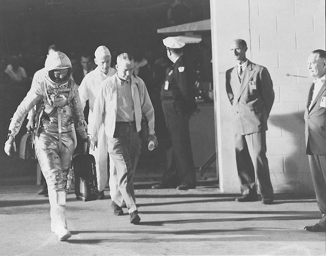 S62-00379 (20 Feb. 1962) --- View of astronaut John H. Glenn Jr., Dr. William Douglas, astronauts' flight surgeon, and equipment specialist Joe Schmitt leaving Operations and Checkout Building prior to the Mercury-Atlas 6 (MA-6) mission. Glenn is in his pressure suit and is carrying the portable ventilation unit. Photo credit: NASA
