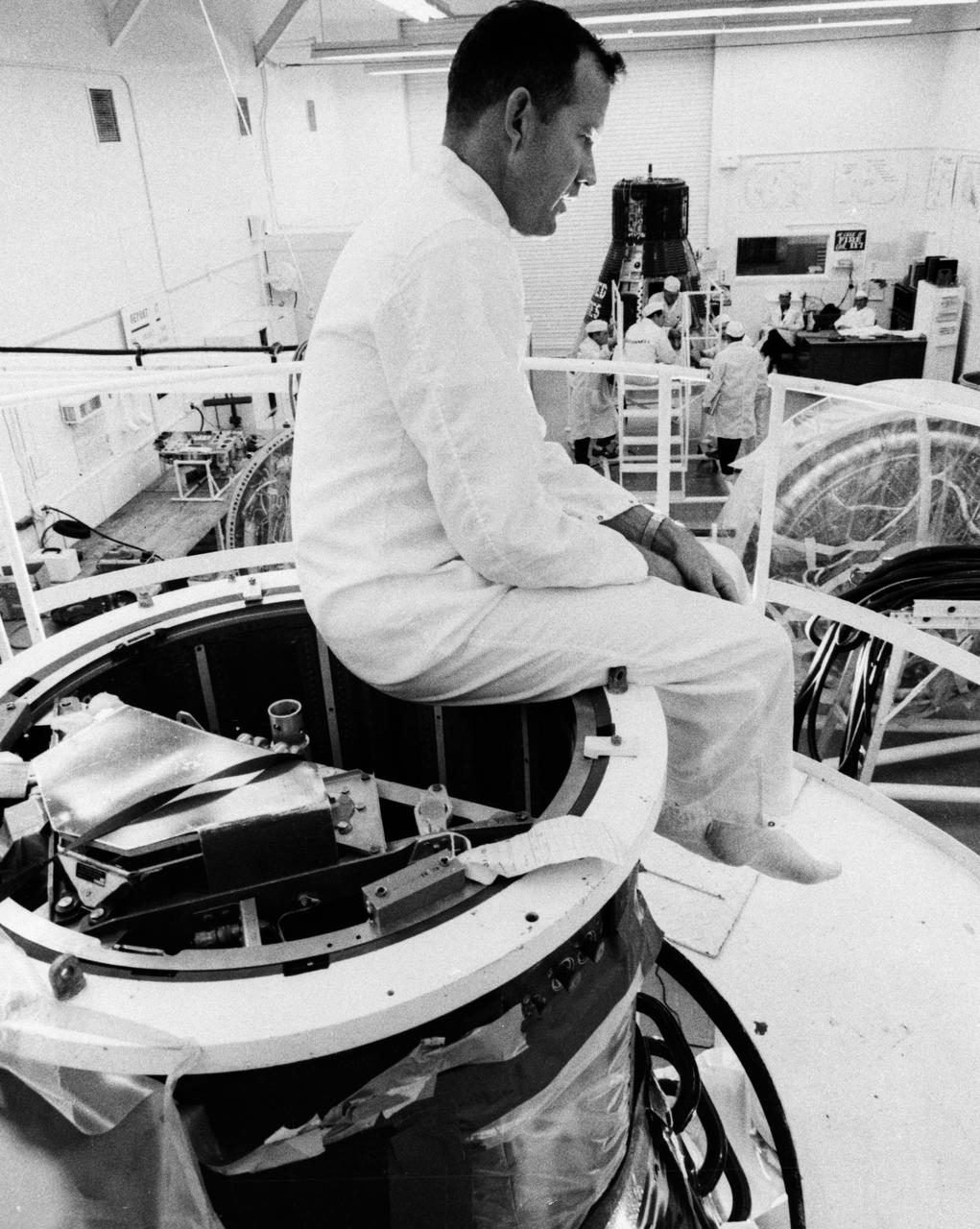 S63-03951 (January 1963) --- Astronaut L. Gordon Cooper Jr., prime pilot for the Mercury-Atlas 9 (MA-9) mission, practices his egress training at Hangar "S" White Room. The pilot may elect to egress from the neck of the spacecraft as shown or by the explosive actuated side hatch. Photo credit: NASA