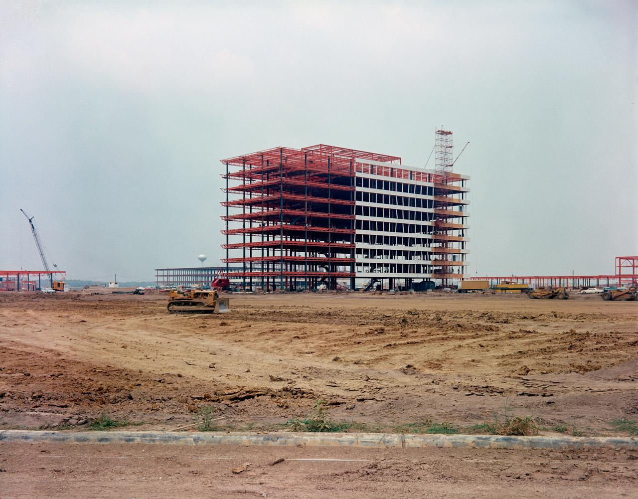S63-06371 (1963) --- Construction continues on the Project Management facility, Building 2, at the Manned Spacecraft Center, some 25 miles southeast of the central business district of Houston, TX.  The building's numerical designation was changed to Building 1 on June 28, 1974, and the center's name became the Johnson Space Center on Feb. 19, 1973. Photo credit: NASA