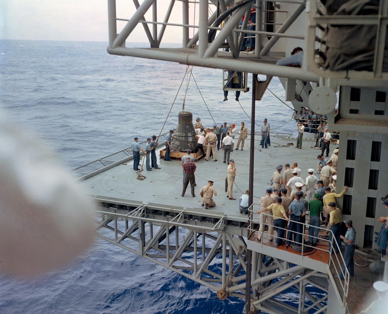 S63-07701 (16 May 1963) --- Recovery Force personnel bring the Mercury-Atlas 9 (MA-9) spacecraft aboard the prime recovery vessel following its successful flight into space. Pilot inside the spacecraft is astronaut L. Gordon Cooper Jr. Photo credit: NASA