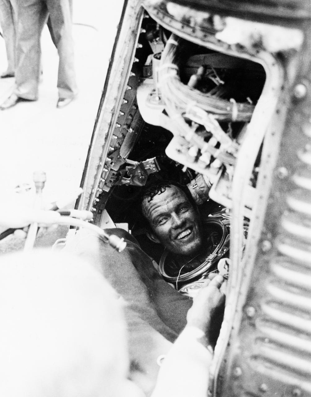 S63-07852 (16 May 1963)--- Astronaut L. Gordon Cooper Jr., pilot of the Mercury-Atlas 9 (MA-9) mission, has a smile for the recovery crew of the USS Kearsarge, after he is onboard from a successful 22-orbit mission of Earth in his spacecraft "Faith 7". Cooper is still sitting in his capsule, with his helmet off. Photo credit: NASA