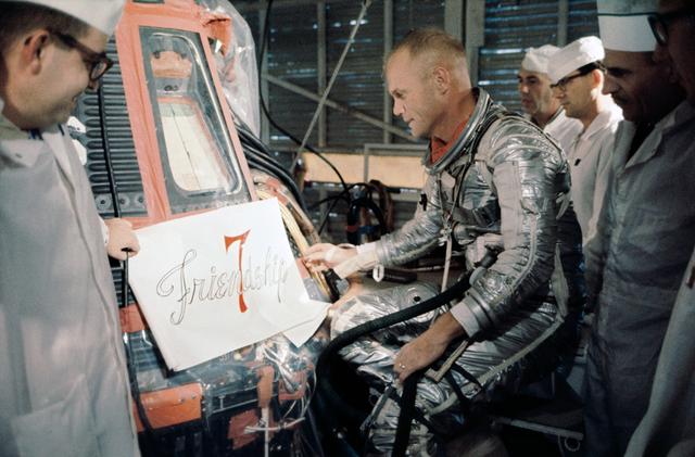 NASA image: Astronaut John Glenn inspects decal for side of his Mercury capsule