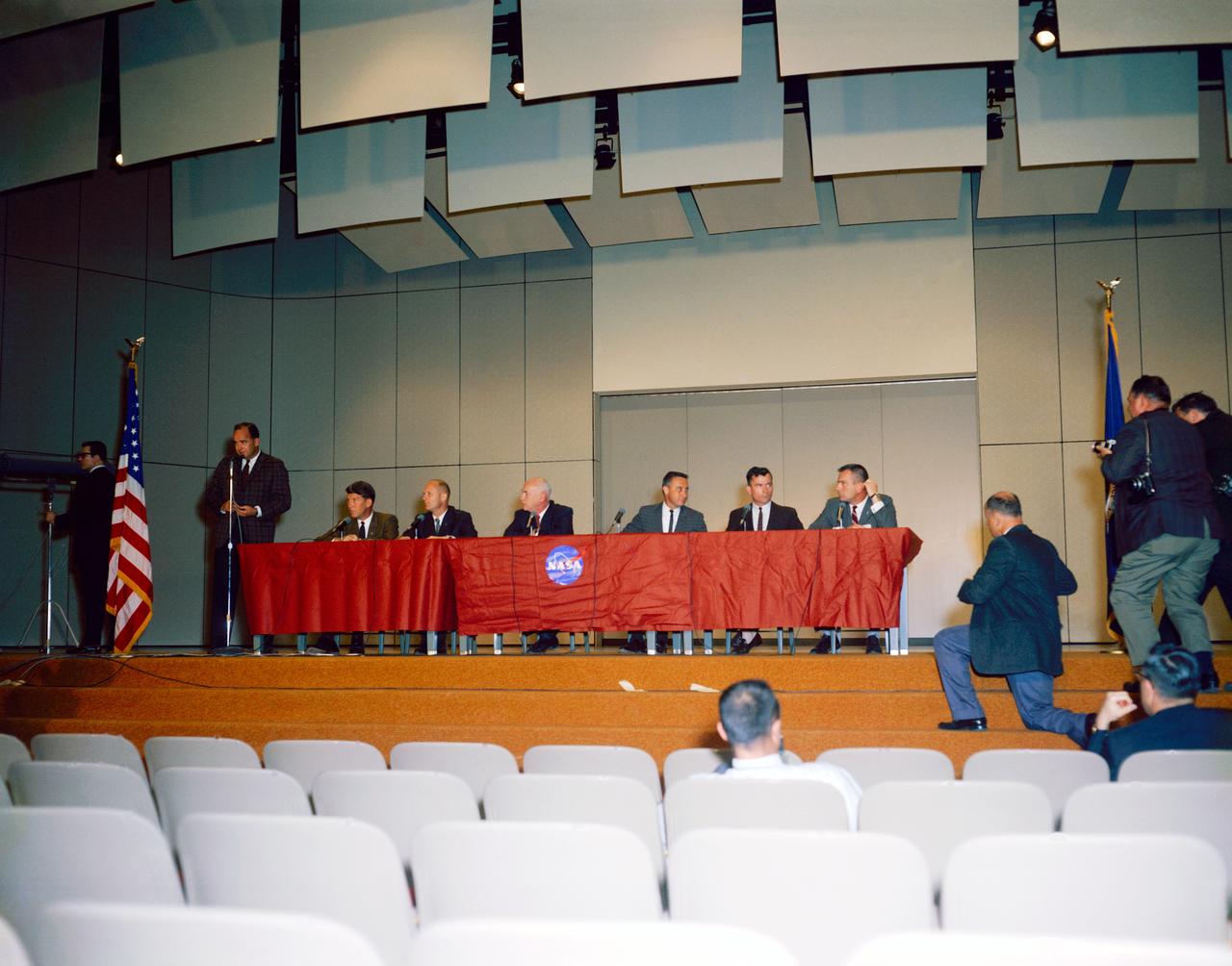 S64-19466 (13 April 1964) --- A press conference was held in the Bldg. 1 auditorium at the NASA Manned Spacecraft Center to announce the first Gemini astronaut selections. Shown left to right are Paul Haney, MSC Public Affairs Officer (standing); astronauts Walter Schirra and Thomas Stafford; Dr. Robert Gilruth, director of MSC; astronauts Virgil Grissom and John Young; and Donald K. Slayton, assistant director of Flight Crew Operations at MSC.