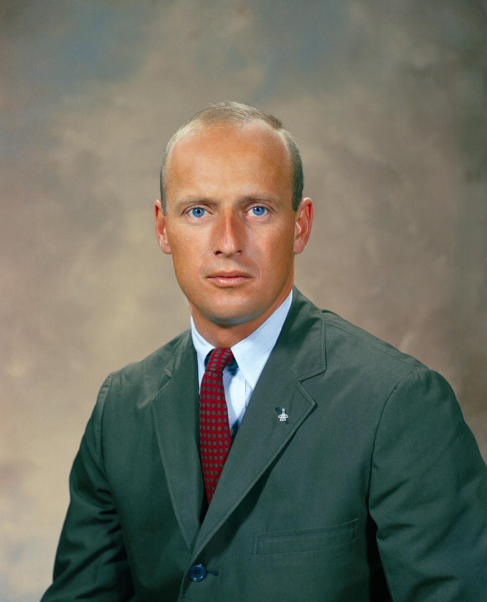 A man wears a suit and sits for his portrait.