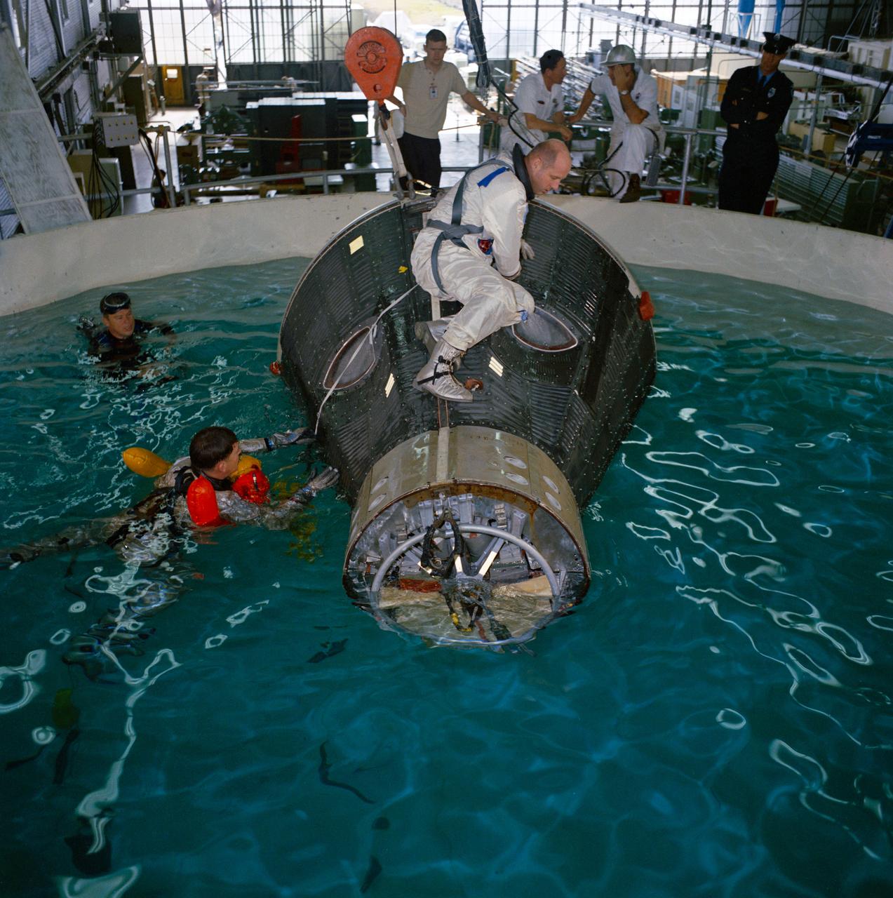 S65-10118 (1 Feb. 1965) --- The Gemini-6 prime crew, astronauts Walter M. Schirra Jr. (in water), command pilot; and Thomas P. Stafford (on spacecraft), pilot, are pictured during water egress training at Ellington Air Force Base, Texas. Photo credit: NASA or National Aeronautics and Space Administration