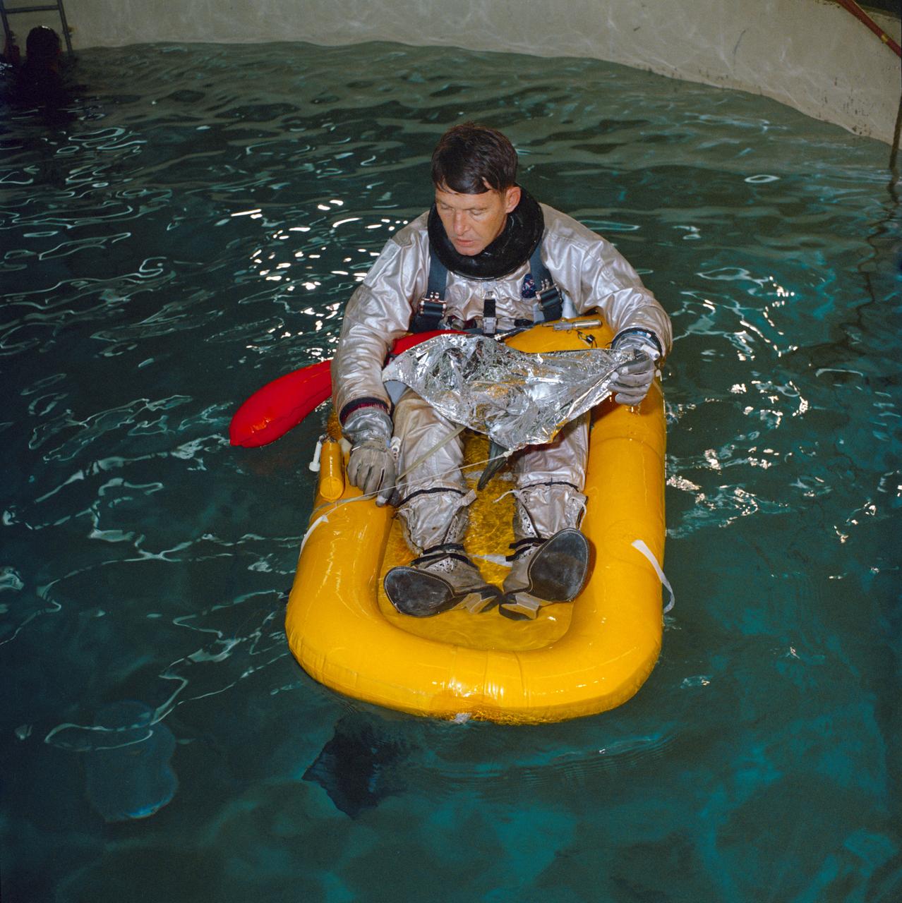 S65-10121 (1 Feb. 1965) --- Astronaut Walter M. Schirra Jr., the Gemini-6 command pilot for the prime crew, floats on a one-man life raft in a pool during water egress training at Ellington Air Force Base, Texas. Photo credit: NASA or National Aeronautics and Space Administration