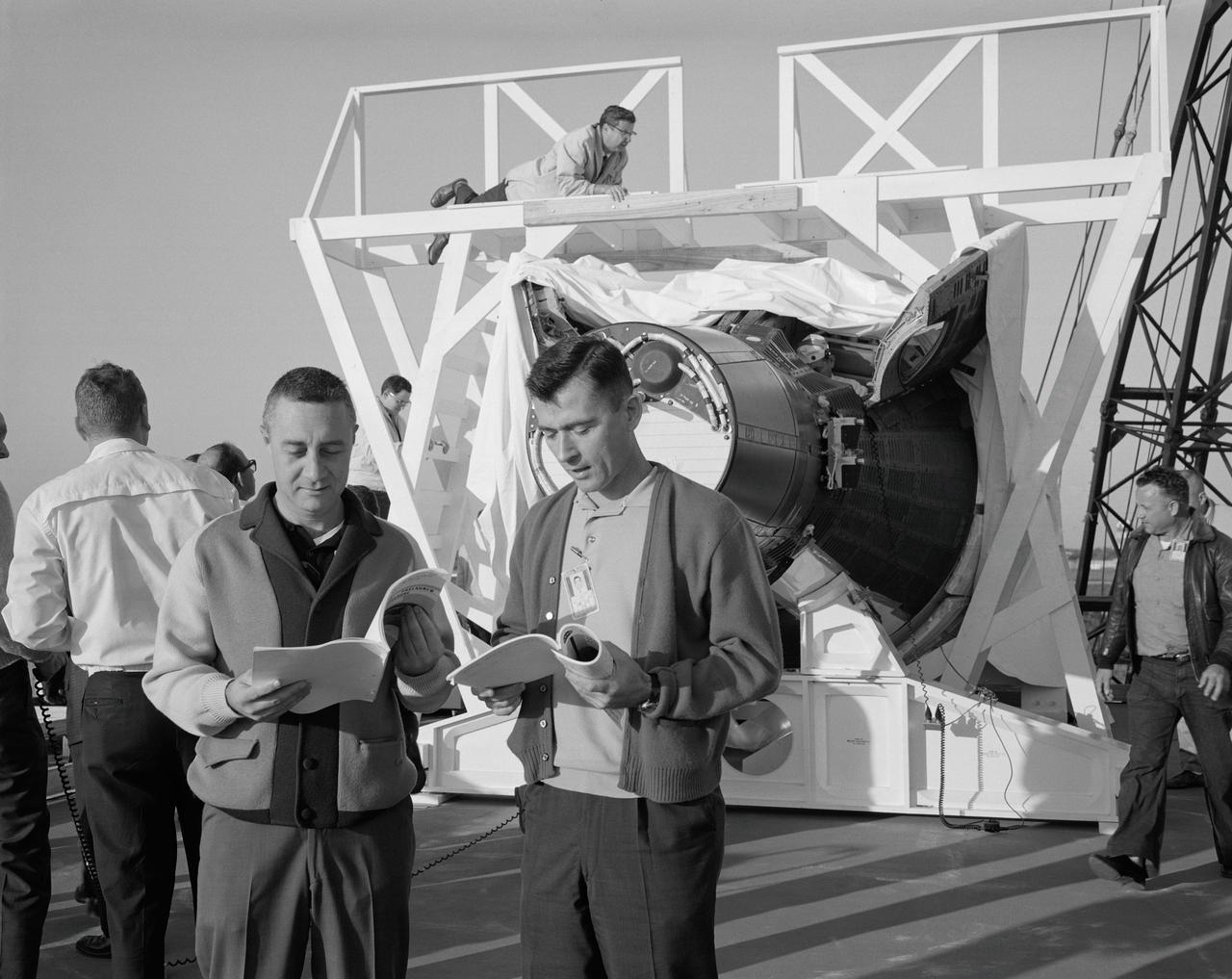 S65-13391 (6 Jan. 1965) --- Astronaut Virgil I. Grissom (left), Gemini-Titan 3 command pilot; and John W. Young, pilot, are shown discussing test plans prior to entering the Gemini-3 spacecraft for a communications test at the Merritt Island test area.